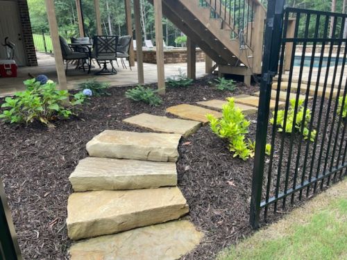  alt='Had trees taken down, stones installed in the beds, drains installed, entire backyard graded, filled and new sod installed,'